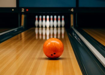 Bowling balls and pins set up on a polished lane, highlighting beginner-friendly bowling setup