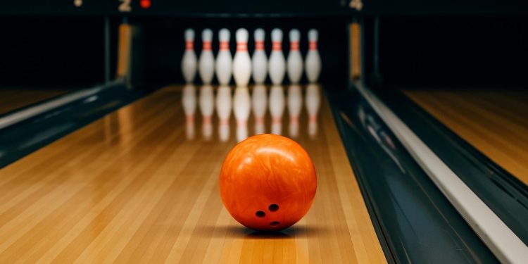 Bowling balls and pins set up on a polished lane, highlighting beginner-friendly bowling setup